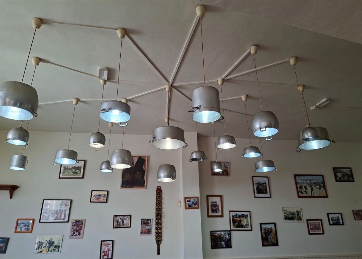 Lámparas hechas con ollas y fotos de ganado en la pared